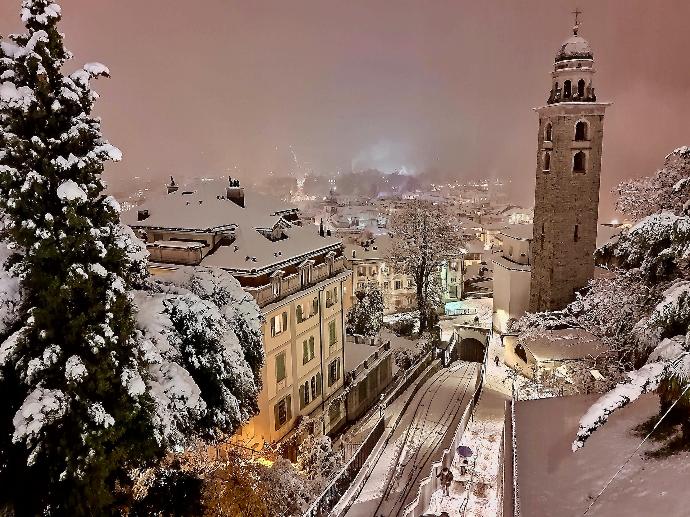 a snowy view of a city with a clock tower